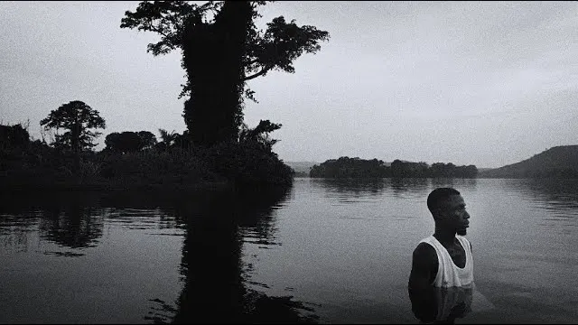 Image du clip Sinatanale : un homme debout dans l'eau d'un lac, en noir et blanc
